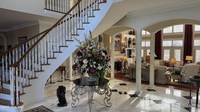 interior space with decorative columns, ornamental molding, and a towering ceiling