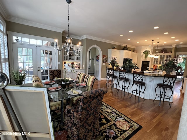 dining space with french doors, ornamental molding, and hardwood / wood-style floors