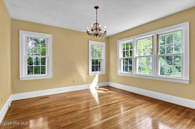 2817 Park Ave, Wilmington, NC 28403 - spare room featuring baseboards, hardwood / wood-style flooring, and a chandelier
