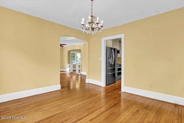 2817 Park Ave, Wilmington, NC 28403 - unfurnished room with arched walkways, light wood-style floors, baseboards, and a chandelier