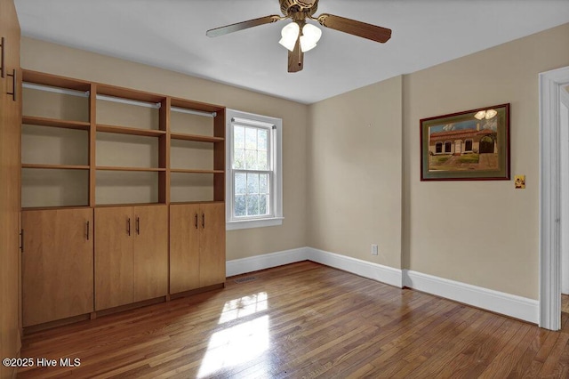 interior space with ceiling fan, baseboards, and wood finished floors