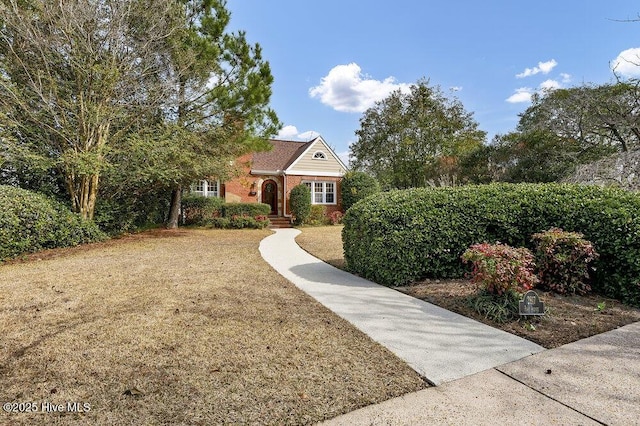 view of front facade featuring brick siding and a front lawn