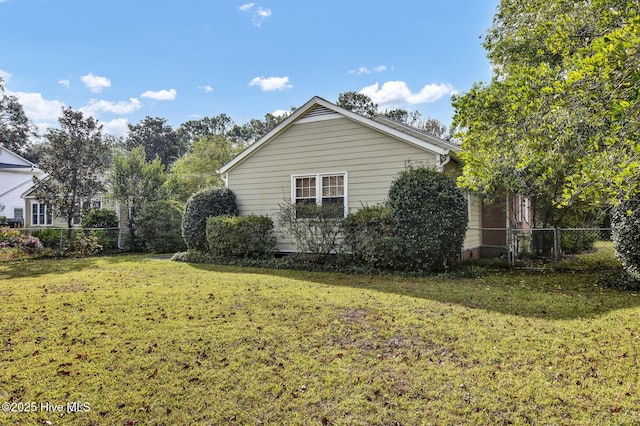 view of property exterior featuring a yard and fence