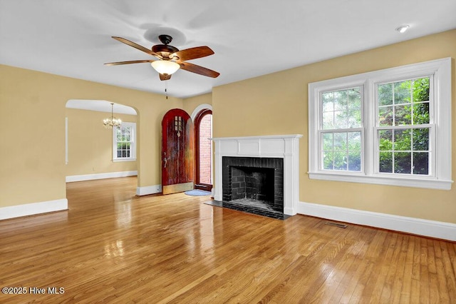 2817 Park Ave, Wilmington, NC 28403 - unfurnished living room featuring baseboards, a ceiling fan, a chandelier, wood finished floors, and a fireplace