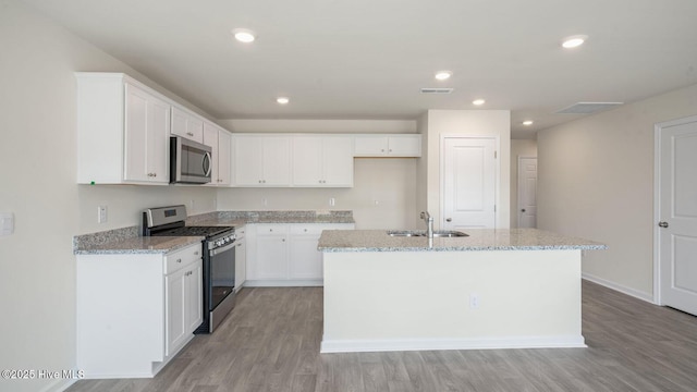 kitchen featuring light stone countertops, appliances with stainless steel finishes, sink, and white cabinets