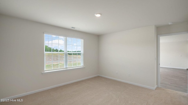 spare room featuring light colored carpet