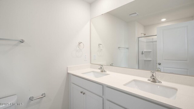 bathroom with walk in shower, vanity, and toilet