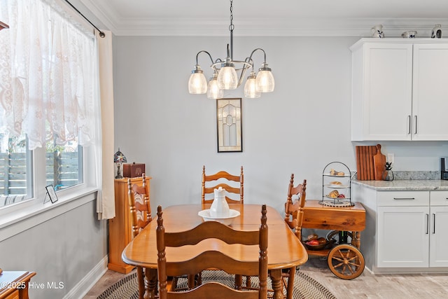 dining space featuring a notable chandelier, baseboards, and ornamental molding