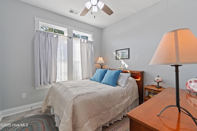 bedroom with baseboards, visible vents, and ceiling fan