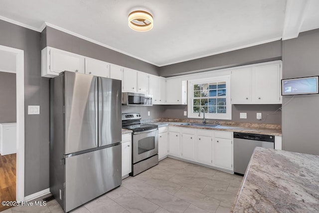 kitchen with white cabinetry, appliances with stainless steel finishes, sink, and ornamental molding