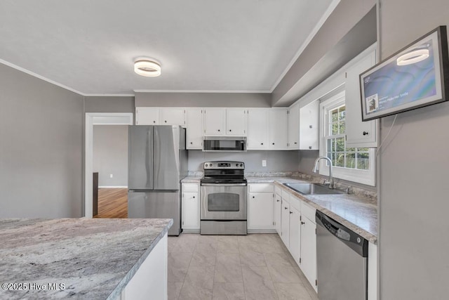 kitchen featuring appliances with stainless steel finishes, sink, white cabinets, ornamental molding, and light stone counters