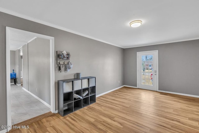 empty room featuring crown molding and light wood-type flooring