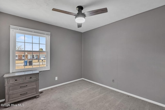 spare room with ceiling fan and light colored carpet