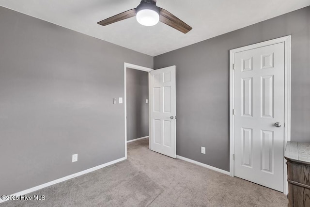 unfurnished bedroom featuring light carpet and ceiling fan