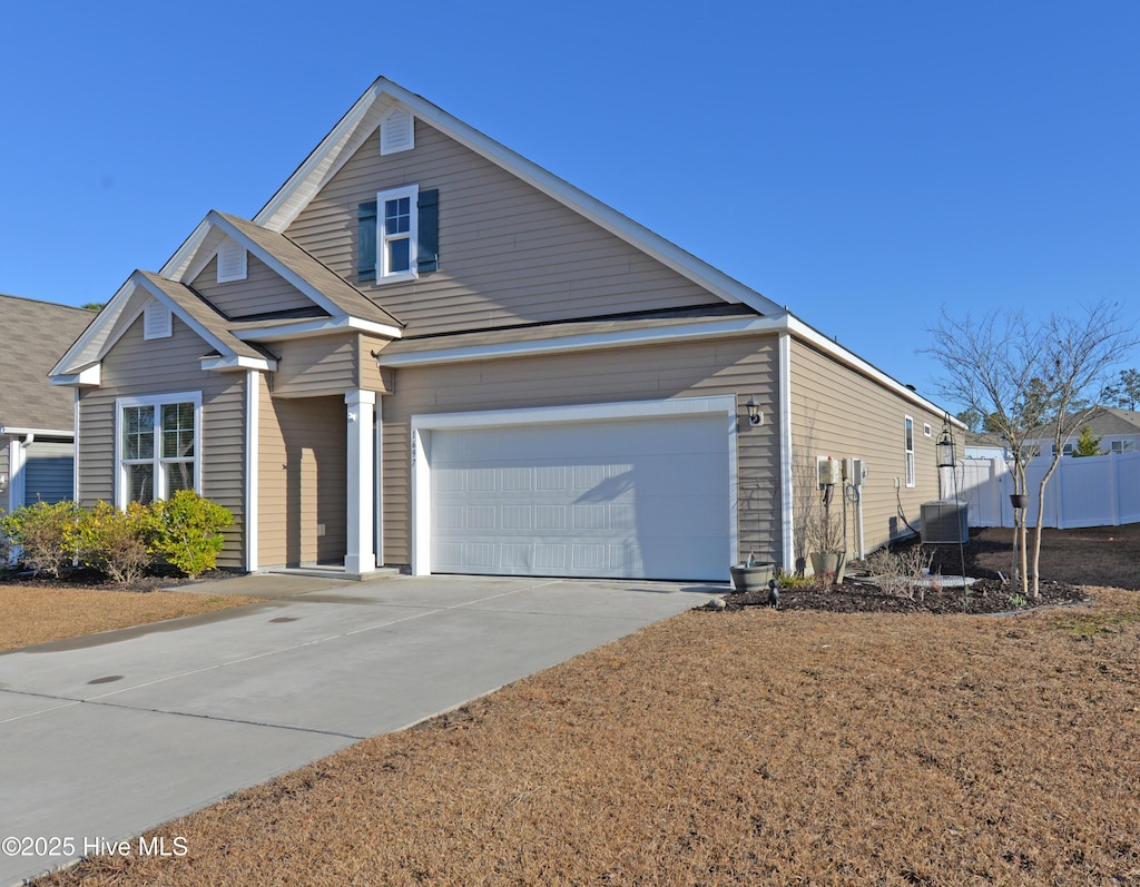 view of front of home with a garage and central AC