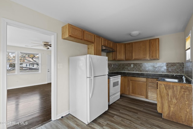 kitchen with sink, white appliances, dark hardwood / wood-style floors, and decorative backsplash