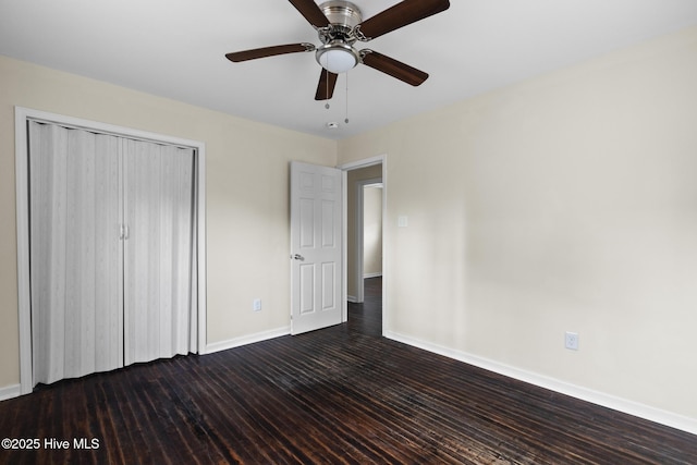 unfurnished bedroom with a closet, dark hardwood / wood-style floors, and ceiling fan