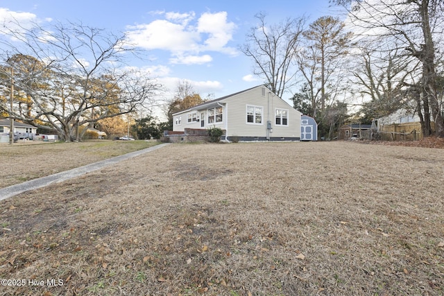 view of side of home featuring a shed and a yard