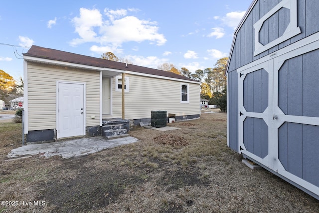 rear view of house featuring a storage shed