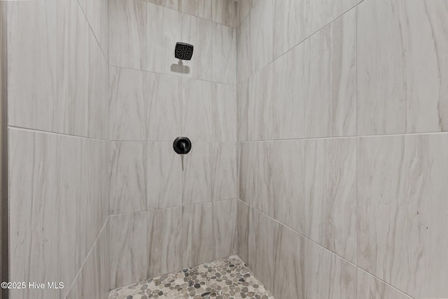 interior details with a tile shower