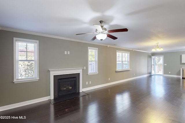 unfurnished living room with ceiling fan with notable chandelier, plenty of natural light, ornamental molding, and dark hardwood / wood-style floors