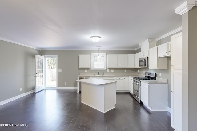 kitchen featuring appliances with stainless steel finishes, white cabinets, hanging light fixtures, a center island, and dark wood-type flooring