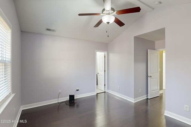 spare room with vaulted ceiling with beams, dark wood-type flooring, ceiling fan, and plenty of natural light