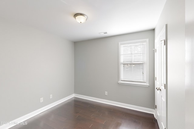 spare room with dark wood-type flooring