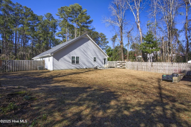 view of side of property with central AC and a yard