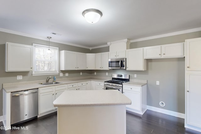 kitchen with sink, appliances with stainless steel finishes, white cabinetry, a kitchen island, and decorative light fixtures