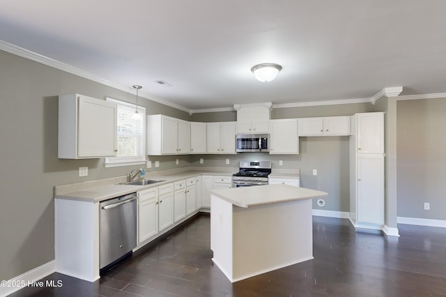 kitchen with sink, appliances with stainless steel finishes, white cabinetry, hanging light fixtures, and a center island