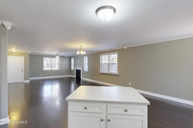 kitchen featuring ornamental molding, a kitchen island, dark wood-type flooring, and white cabinets