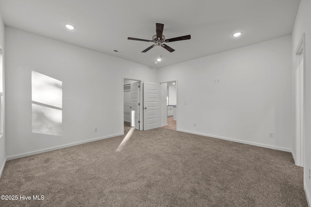 unfurnished bedroom featuring ceiling fan, carpet flooring, and a spacious closet