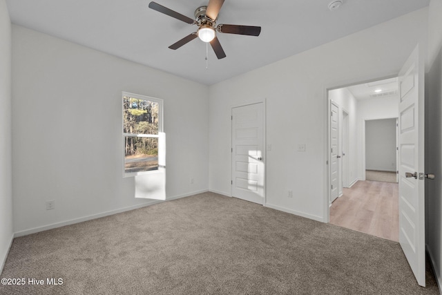 carpeted spare room with ceiling fan