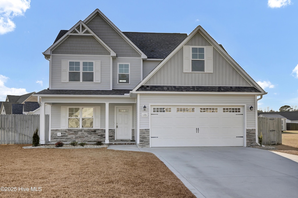 craftsman inspired home with a garage and a front yard