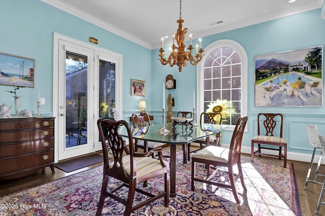 dining space featuring crown molding, dark wood-type flooring, and an inviting chandelier