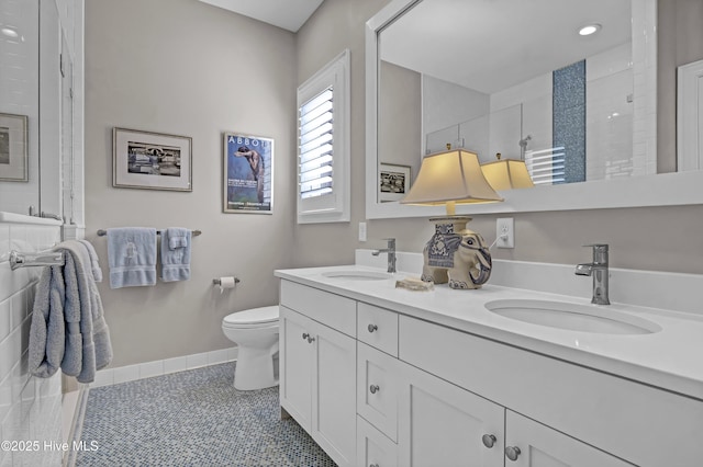 bathroom featuring tile patterned flooring, toilet, vanity, and a shower with shower door