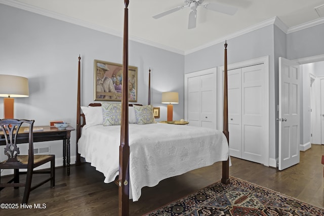 bedroom with ceiling fan, ornamental molding, dark hardwood / wood-style floors, and two closets