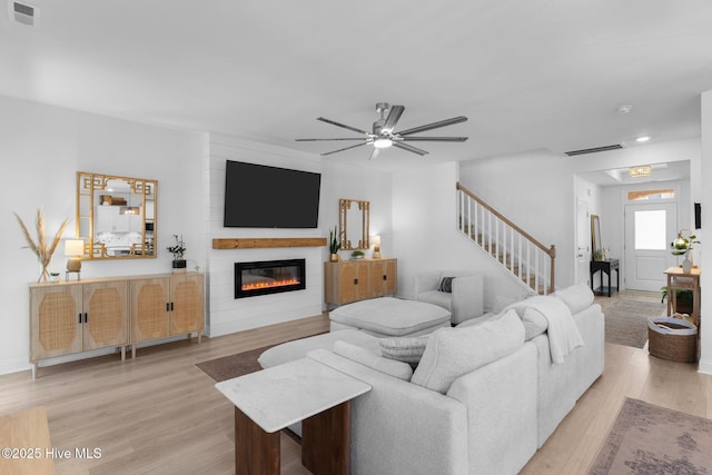 living room with ceiling fan and light hardwood / wood-style flooring