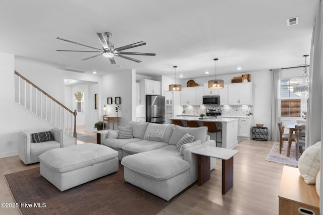 living room with an inviting chandelier and light wood-type flooring