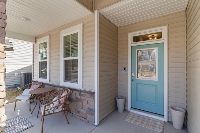 entrance to property featuring a porch and central AC