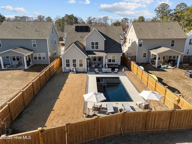 rear view of house featuring a fenced in pool, a patio, and outdoor lounge area