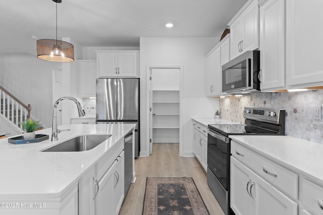 kitchen with white cabinetry, sink, pendant lighting, and appliances with stainless steel finishes