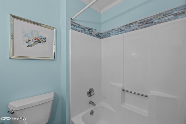 bathroom with washtub / shower combination, ornamental molding, and toilet