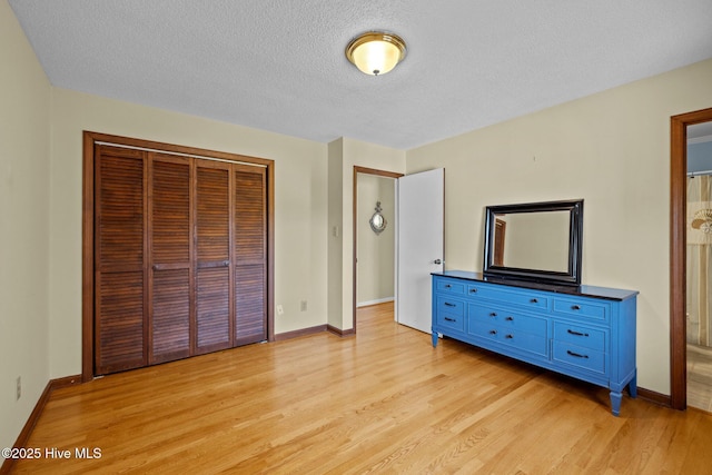 unfurnished bedroom featuring light hardwood / wood-style floors, a closet, and a textured ceiling