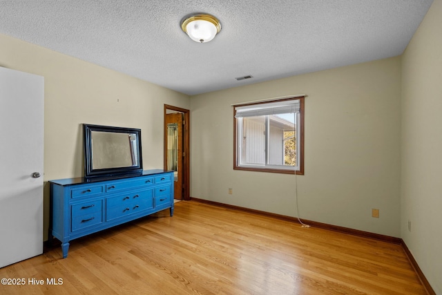 unfurnished bedroom featuring a textured ceiling and light wood-type flooring