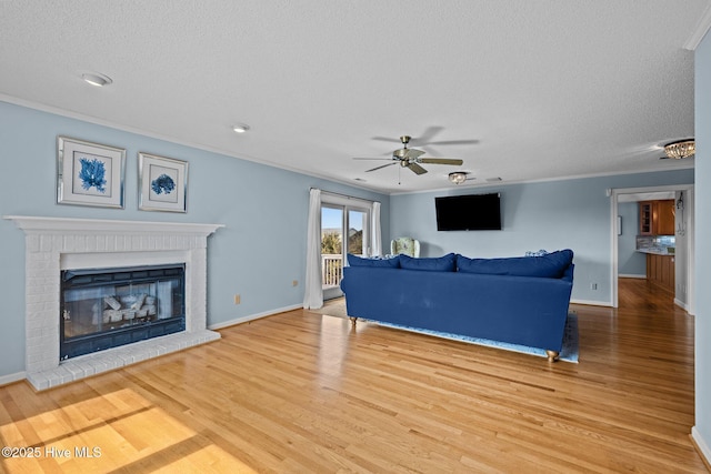 living room with crown molding, a fireplace, a textured ceiling, and wood-type flooring