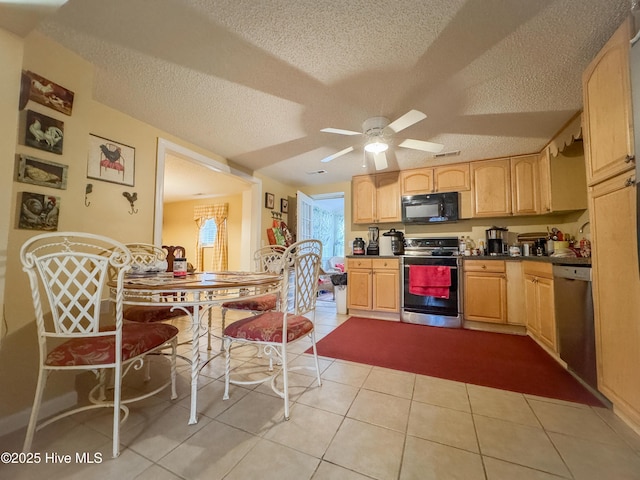 kitchen featuring light tile patterned floors, ceiling fan, stainless steel appliances, a textured ceiling, and light brown cabinets