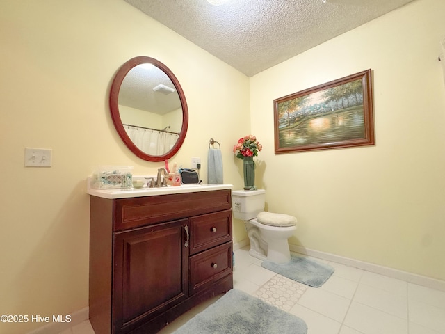 bathroom featuring vanity, tile patterned floors, toilet, and a textured ceiling