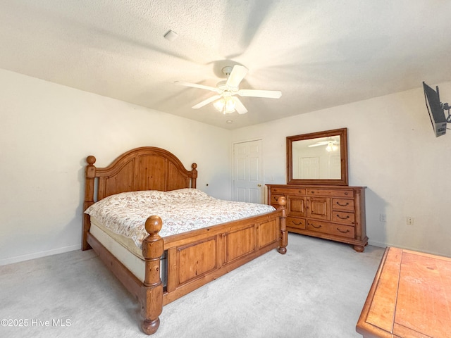 carpeted bedroom featuring ceiling fan and a textured ceiling